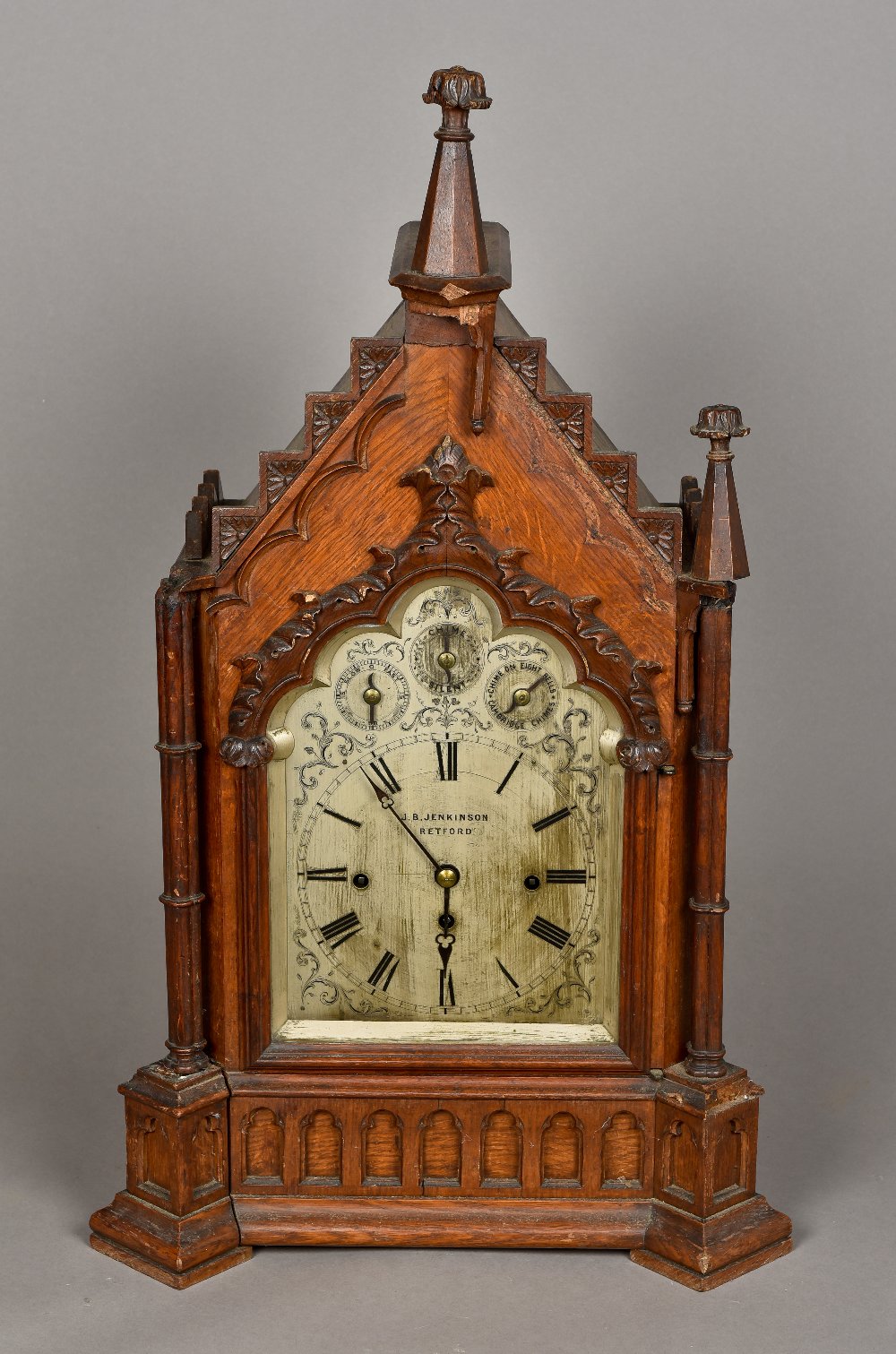 A Victorian oak Gothic architectural cased chiming bracket clock The silvered dial with Roman