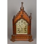 A Victorian oak Gothic architectural cased chiming bracket clock The silvered dial with Roman