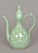 A celadon glazed Korean ewer Of double gourd form, decorated with cranes amongst clouds.