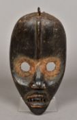 An African carved wooden tribal mask, possibly the Dan People of Liberia With typical pointed head,