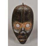 An African carved wooden tribal mask, possibly the Dan People of Liberia With typical pointed head,