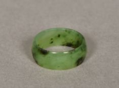 A small spinach jade ring Of band form. 8mm deep.