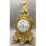 A 19th century French ormolu mantel clock The florally scroll cast case surmounted with a cherub,