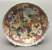 An 18th century Chinese porcelain saucer Decorated with figures in a fenced garden within landscape