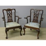 A pair of 19th century mahogany open armchairs The floral and scroll carved top rail above the