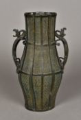 A Chinese cast bronze vase Of ribbed baluster form, the handles worked as dragons. 32.5 cm high.
