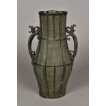 A Chinese cast bronze vase Of ribbed baluster form, the handles worked as dragons. 32.5 cm high.