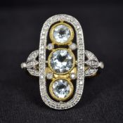 An Art Deco style 18K gold, diamond and aquamarine ring Of pierced rounded rectangular form,