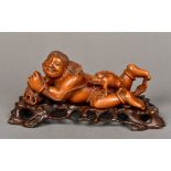 A well carved 19th century Chinese boxwood carving of a boy Modelled recumbent,