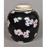 A Chinese porcelain ginger jar Over painted with prunus flowers on a black ground. 23 cm high.