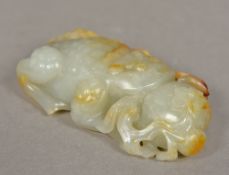 A Chinese carved white and russet jade group Worked as a toad with a pomegranate. 11 cm long.