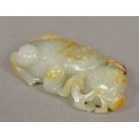 A Chinese carved white and russet jade group Worked as a toad with a pomegranate. 11 cm long.