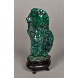 A malachite scholars rock With polished surface, mounted on an ebonised display plinth. 17 cm high.