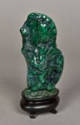 A malachite scholars rock With polished surface, mounted on an ebonised display plinth. 17 cm high.