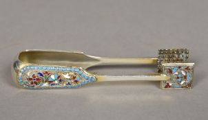 A pair of Russian enamel decorated silver tongs, mark indistinct With scrolling floral decorations.