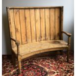 A 19th century pine and elm barrel back settle The panelled curved back issuing twin open arms,