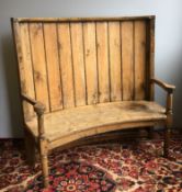 A 19th century pine and elm barrel back settle The panelled curved back issuing twin open arms,