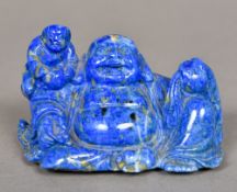 A Chinese carved lapis Buddha Modelled seated with child attendant. 5.5 cm high.