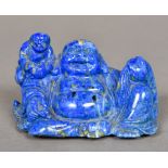 A Chinese carved lapis Buddha Modelled seated with child attendant. 5.5 cm high.