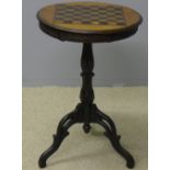 A 19th century carved oak tripod games table The circular top with inlaid games board above the