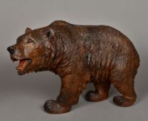 A large finely carved wooden Black Forest bear Naturalistically modelled on all fours,