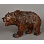 A large finely carved wooden Black Forest bear Naturalistically modelled on all fours,