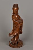 A 19th century Chinese carved hardwood figure of Guanyin Modelled standing in flowing robes above a
