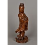 A 19th century Chinese carved hardwood figure of Guanyin Modelled standing in flowing robes above a