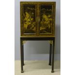 A late 19th/early 20th century chinoiserie lacquered cabinet on stand The top section decorated in