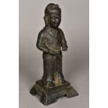 A Chinese cast bronze figure Modelled standing in traditional costume, on an integral plinth base.