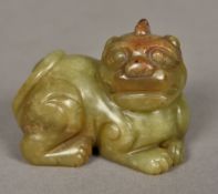 A Chinese carved green and russet jade temple lion Typically worked. 7 cm wide.