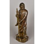 A Chinese cast bronze figure of a Lohan Modelled standing in decorated robes holding a staff,