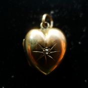 An Edwardian rose gold heart shaped photo locket set with a diamond