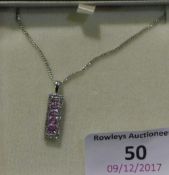 A boxed 9 ct white gold pendant set with pink sapphires and diamonds on a 9 ct white gold chain