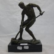 A bronze model of a nude man digging