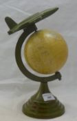 A small globe surmounted with an aeroplane