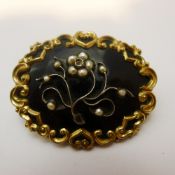 A Victorian yellow metal onyx and seed pearl mourning brooch