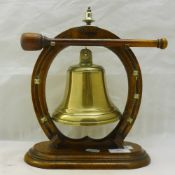 A gunmetal gong on an oak horseshoe stand