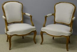 A pair of French upholstered open armchairs Each with a padded back and twin scrolling padded open