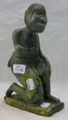 A carved figure of a kneeling slave, possibly nephrite,
