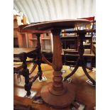 A Victorian circular mahogany lamp table raised on turned baluster support with circular base