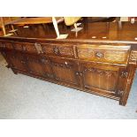 A carved four drawer sideboard with cupboards under