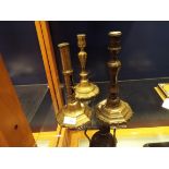 An early 19thC brass ejector candlestick together with two other brass candlesticks