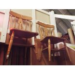 A pair of beech farmhouse kitchen chairs with spindle and pierced splat backs raised on turned