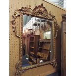 A late 18thC / early 19thC gilt gesso mirror decorated with swags and garlands surmounted by a