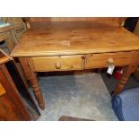 A pine table fitted with a pair of frieze drawers and raised on turned supports