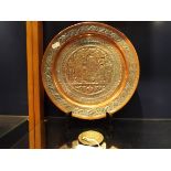 A Persian copper and white metal plate with embossed decoration and an Islamic silver compact with