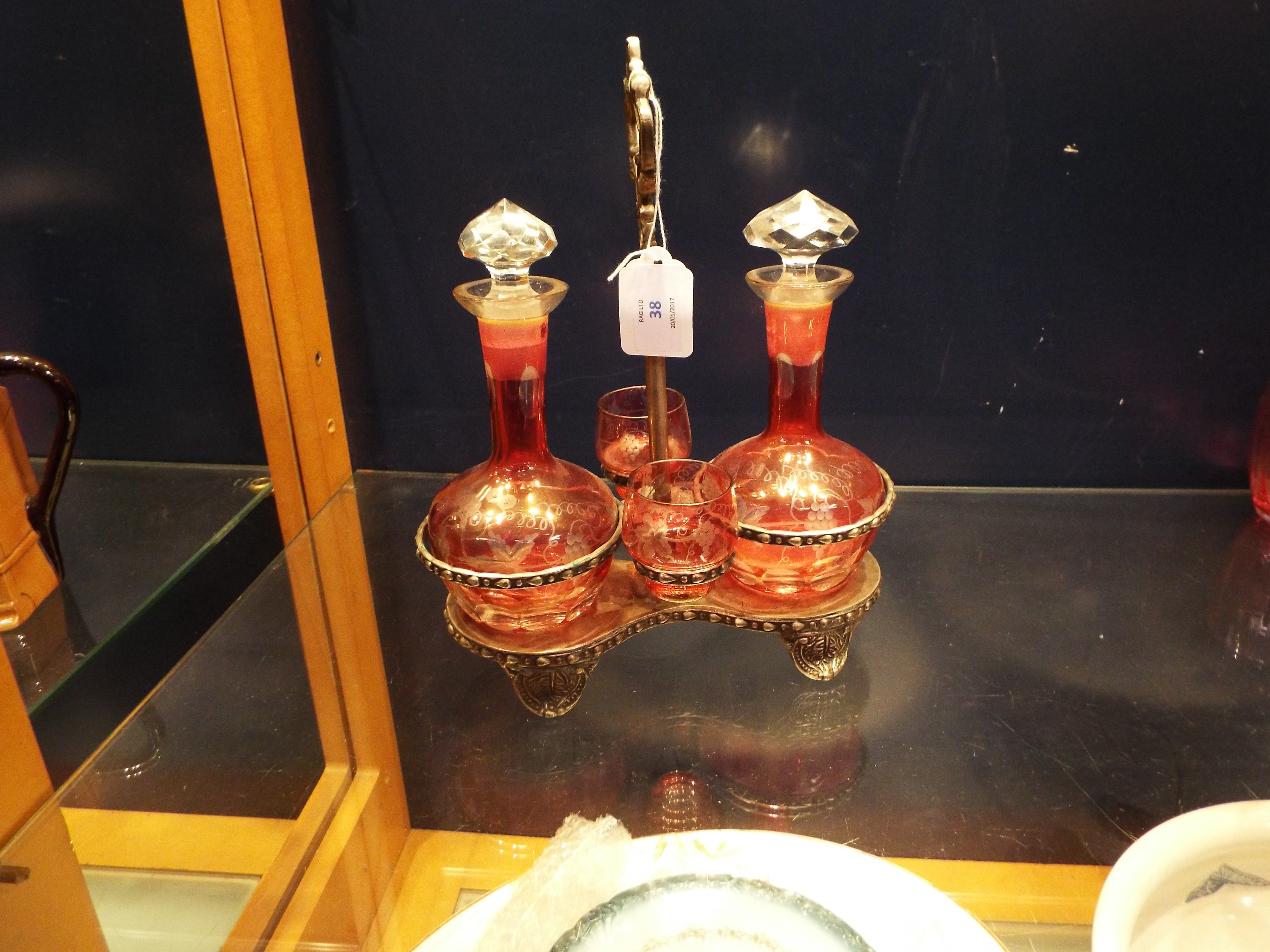 A pair of early 20thC cranberry glass liqueur decanters engraved with grapes and vines with two