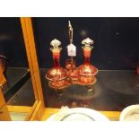 A pair of early 20thC cranberry glass liqueur decanters engraved with grapes and vines with two