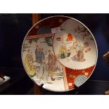 An Imari decorated charger having figures in courtyard scenes,